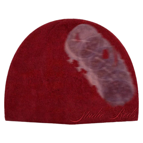 A dark red knit beanie hat featuring a large, semi-transparent ghosted image of stopwatches on the right side, with the brand name 'Studio Reds' embroidered in red script near the bottom.